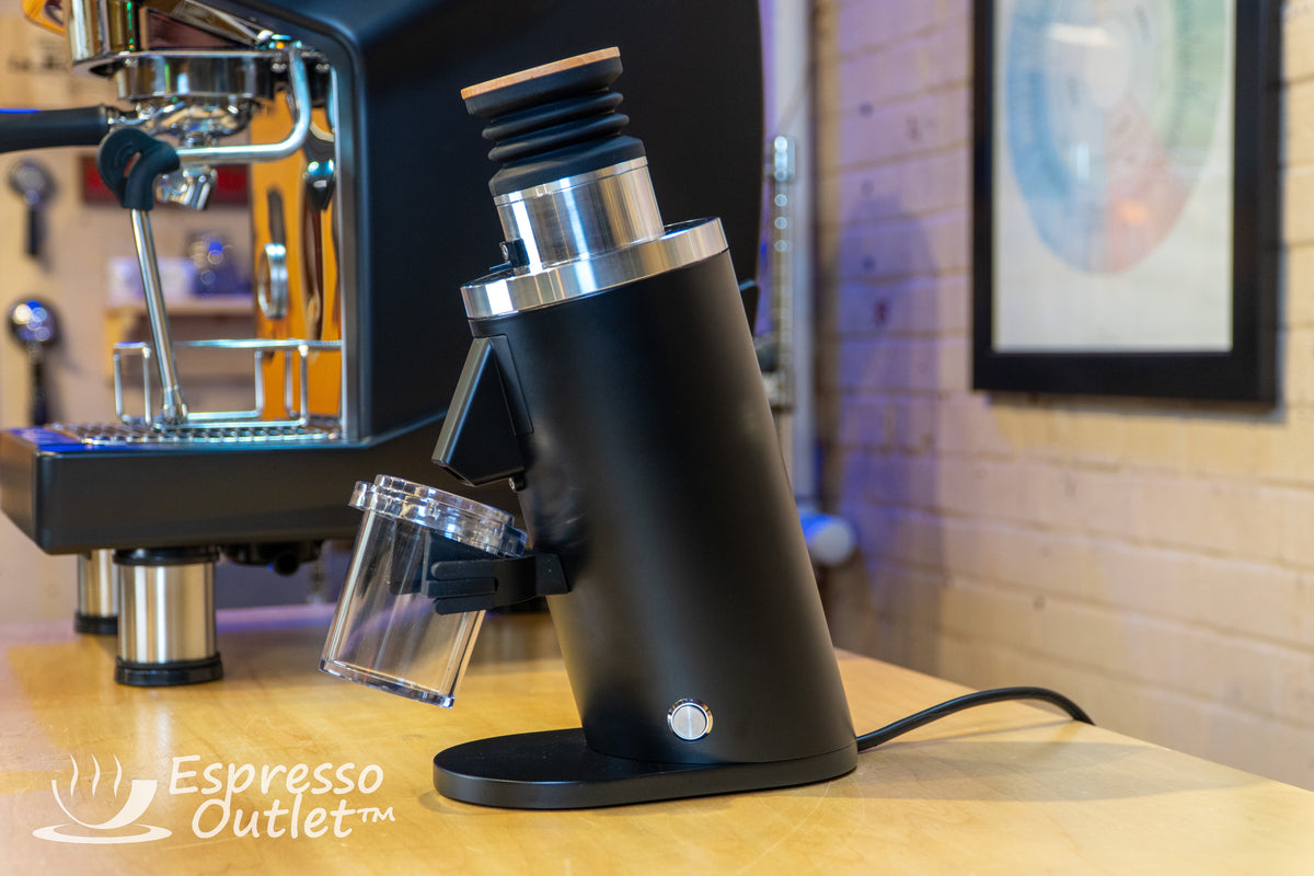 DF54 beside an espresso machine on a wooden counter